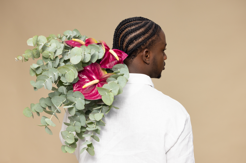 Person holding a bouquet of flowers with a beige background