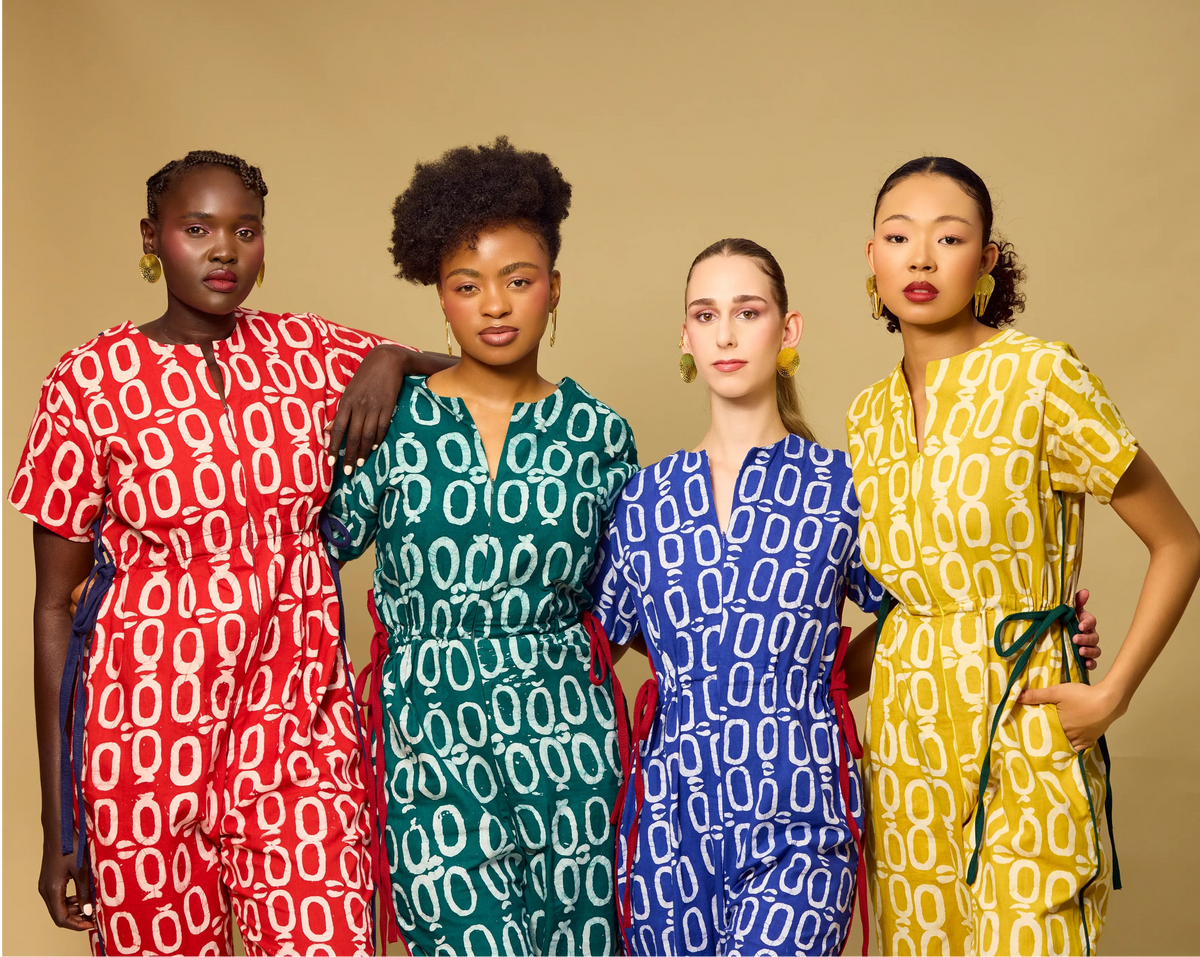 Four women wearing patterned outfits on a beige background